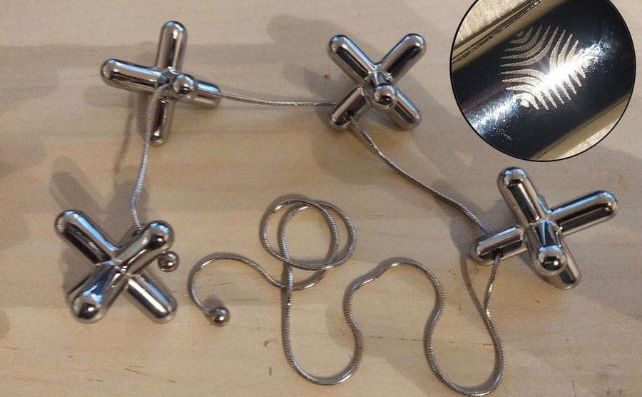 Four metal knucklebones attached with a string make up a trivet that can be adjusted to match the pot's shape. 