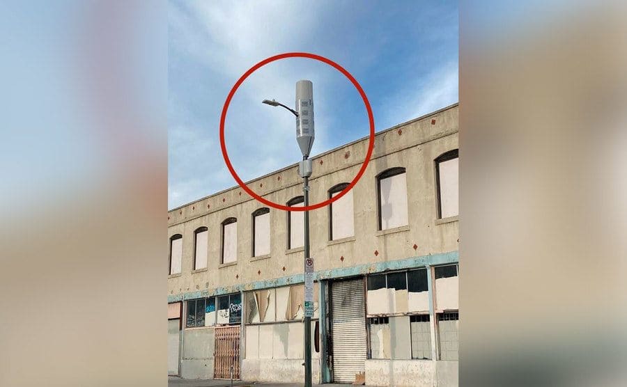 A strange-looking device on top of a pole on the street. 