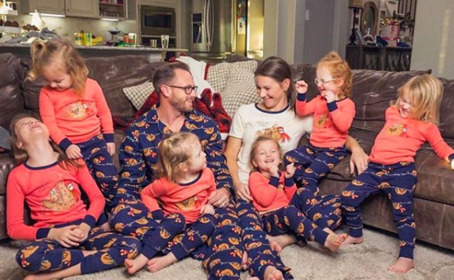 The Busby family is having a pajama party on the floor in their living room. 
