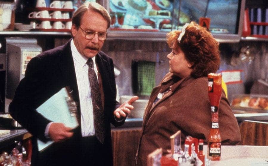 Martin Mull talking to Roseanne Barr in a diner in a scene from Roseanne 