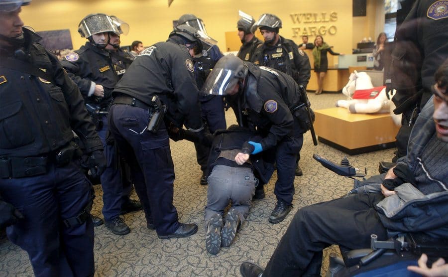 Policemen arrest a man inside a Wells Fargo Bank branch. 