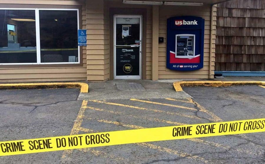 Police tape outside the entrance to a bank. 