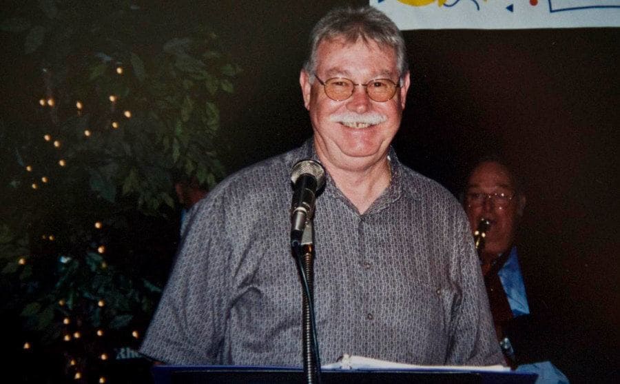 A smiling Adair is standing on stage during an event. 