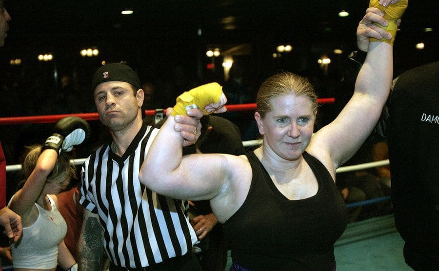 A referee holding up Tonya Harding's arm in the boxing ring 