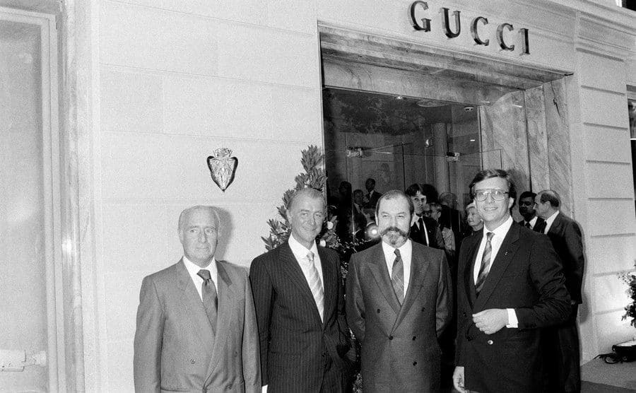 Roberto Gucci, Giorgio Gucci, and Maurizio Gucci are standing before one of the Gucci locations in Paris. 