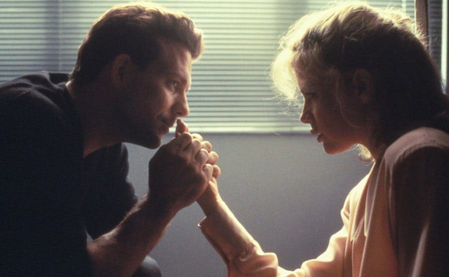Rourke is holding on to Basinger’s hand as he starts deeply into her eyes. 