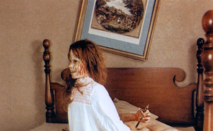 Linda Blair is sitting on the bed with the dummy head facing the wrong direction. 