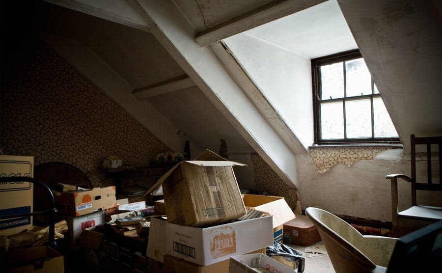 A house attic filled with old boxes filled with files, papers, and photos. 