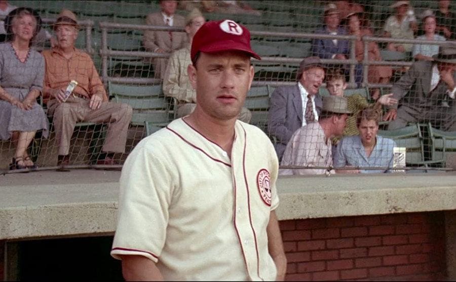 Jimmy Dugan, played by Tom Hanks, stands by the dugout during a game. 