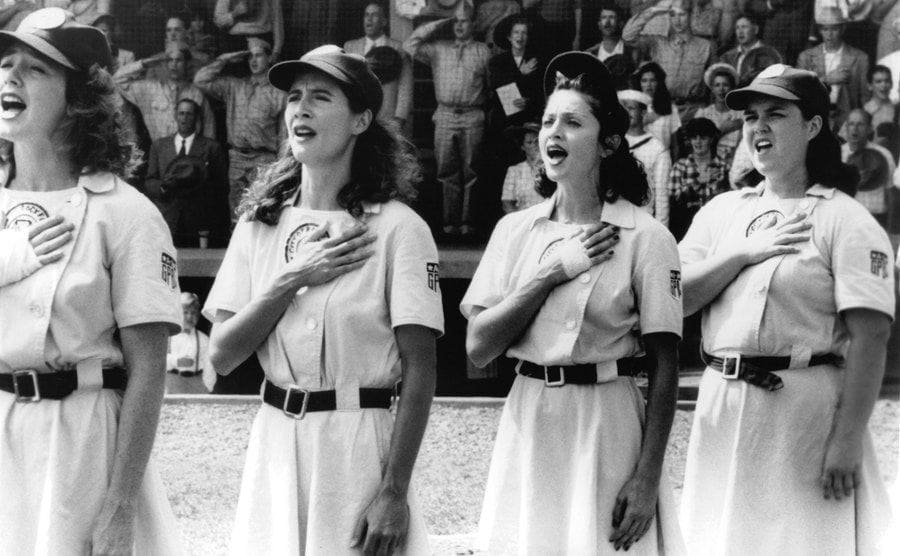 Anne Ramsay, Madonna, and Rosie O’Donnell signing the anthem in a scene from A League of Their Own. 
