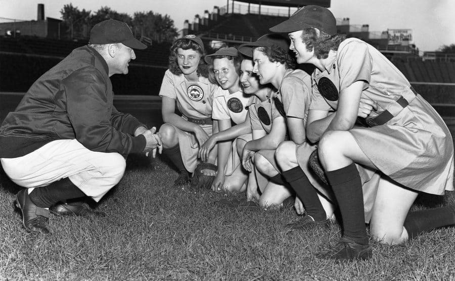 Eddie Stumpf crouching with five of his players as he gives them instructions. 