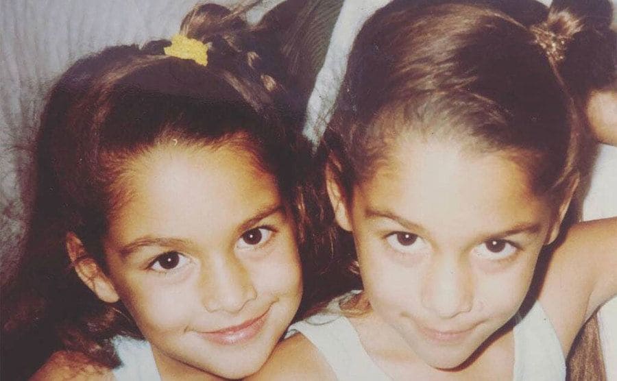 A photo of Nikki Bella and Brie Bella as young girls with side braids in their hair. 