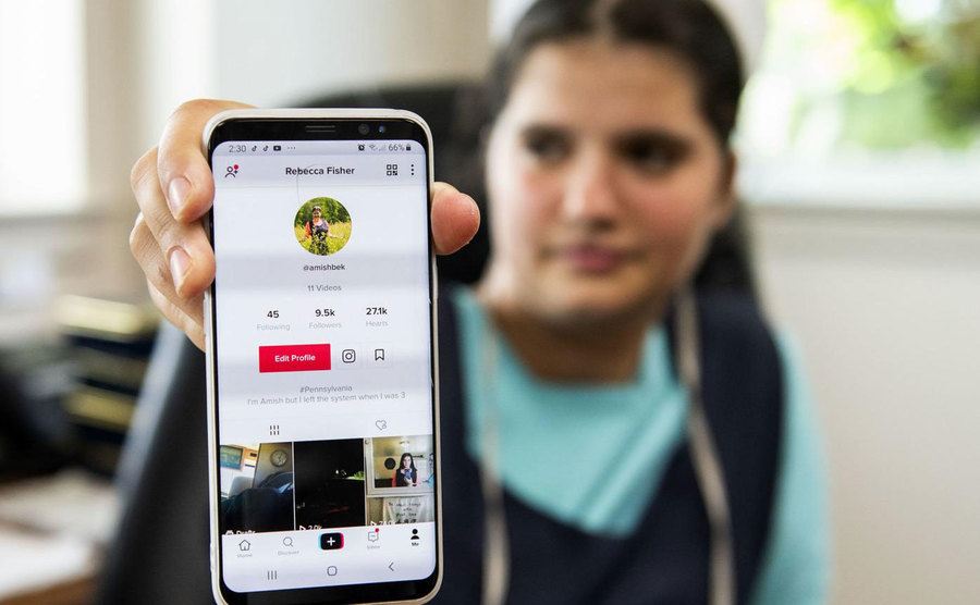 An Amish girl shows off her Tiktok profile on her smartphone. 