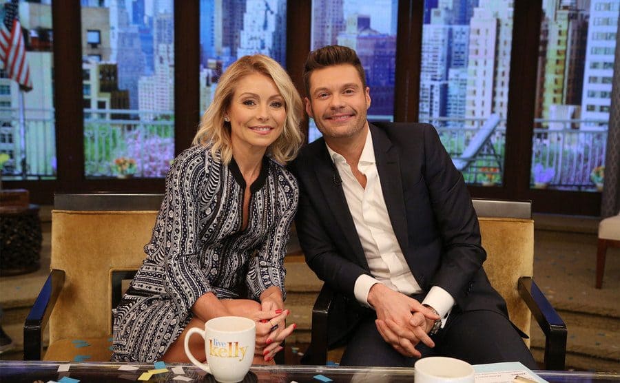Kelly Ripa and Ryan Seacrest are sitting on the set of ‘Live! With Kelly and Ryan’. 