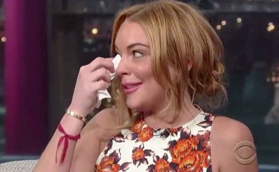 Lohan is wiping away tears with a tissue during her interview with Letterman. 