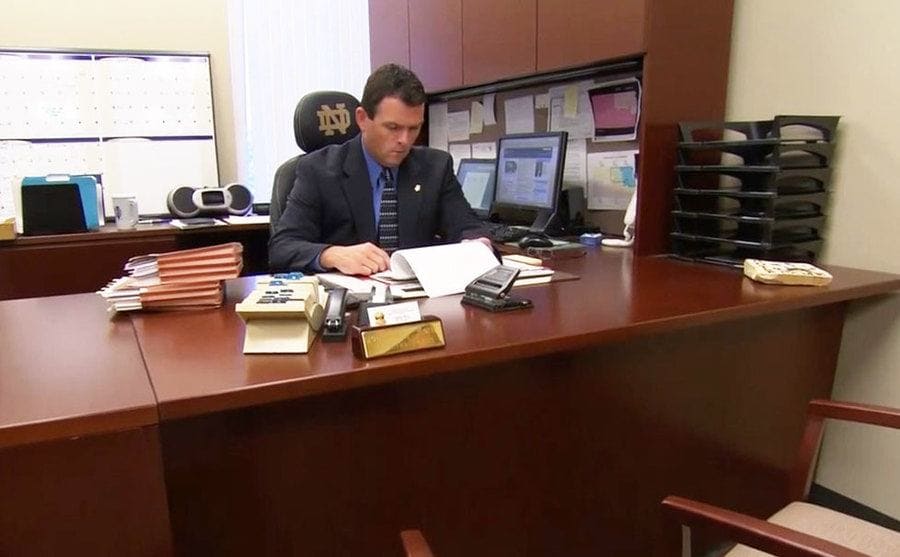 The investigator is sitting on his desk, going through the investigation files.