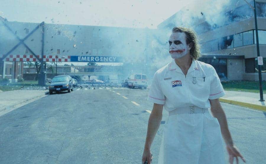 Ledger is walking away from the hospital as it explodes behind him. 