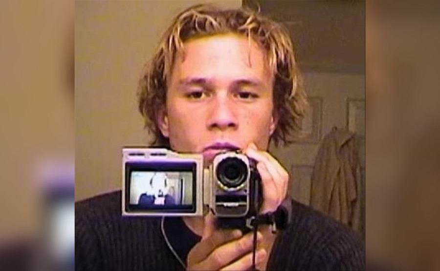Ledger is filming himself in his bathroom mirror. 