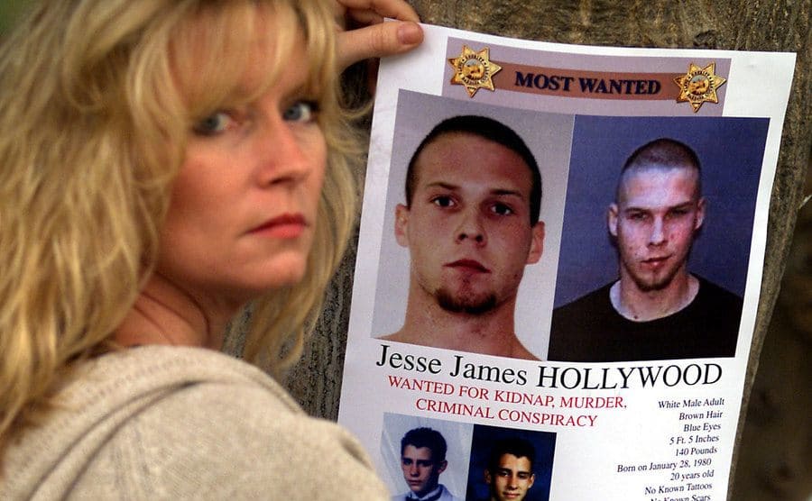 Susan Markowitz is holding a wanted poster for Jesse James Hollywood, wanted for her son's kidnapping.