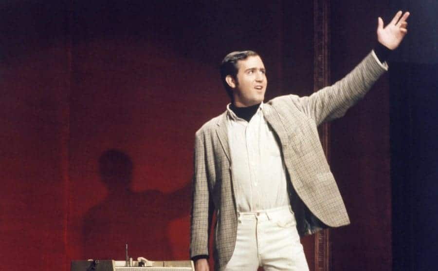 A still of Andy Kaufman performing on stage from Saturday Night Live show. 