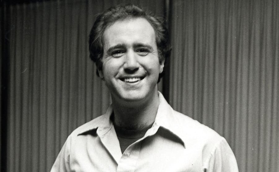 Andy Kaufman is smiling at the camera during the 