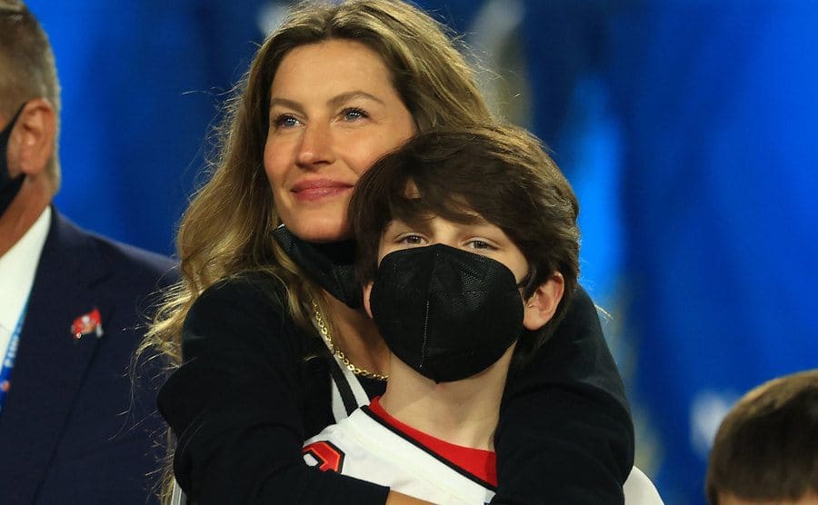 Gisele Bundchen is hugging John Moynahan as they celebrate Tom Brady's victory in the game.