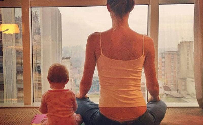 Gisele and her new baby girl are sitting next to each other as they meditate.