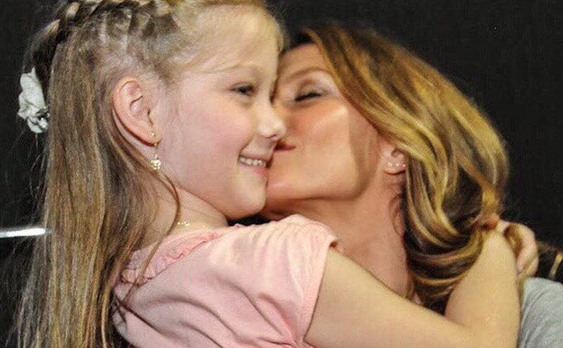 Gisele is giving a birthday kiss to her daughter Vivian.