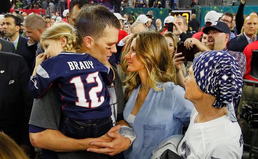 Tom is celebrating the end of the game with his wife, Gisele, his daughter Vivian, and his mother, Galynn.