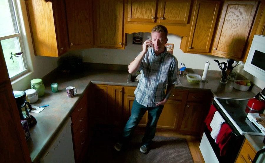 Kroupa is standing in his kitchen while he talks on the phone.