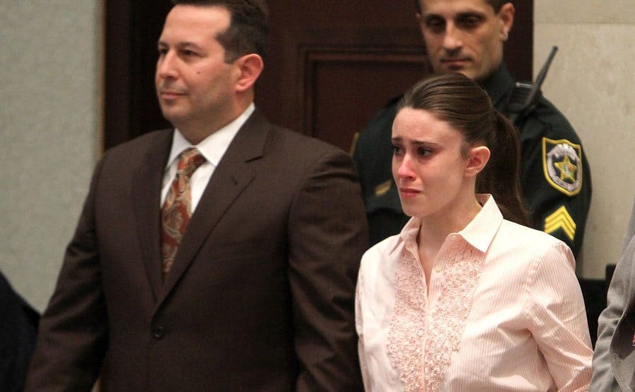 Casey stands next to Jose Baez, a tearful expression on her face. 