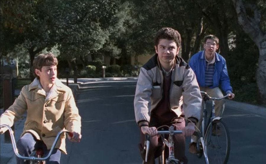 Martin Starr, Samm Levine, and John Francis Daley ride bikes in a still from ‘Freaks and Geeks’ 