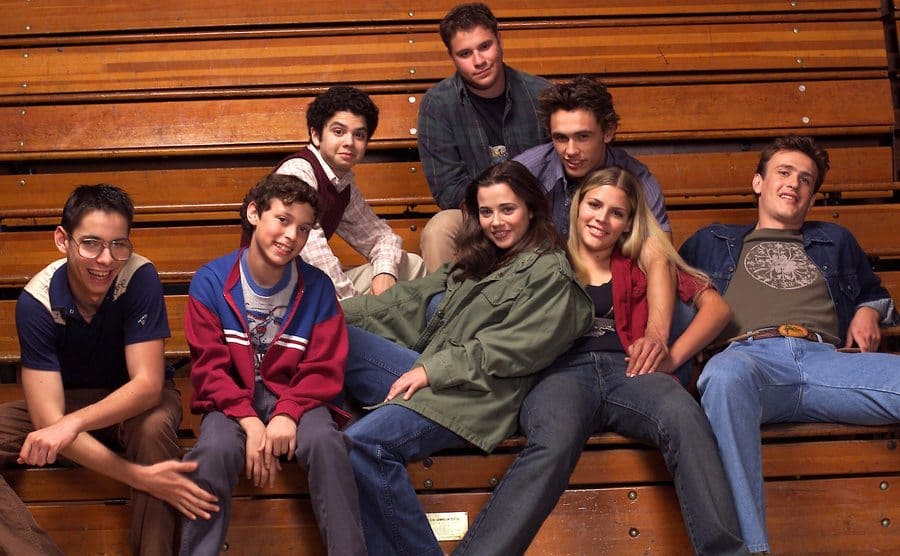 The cast of ‘Freaks and Geeks’ sits on the bleachers. 