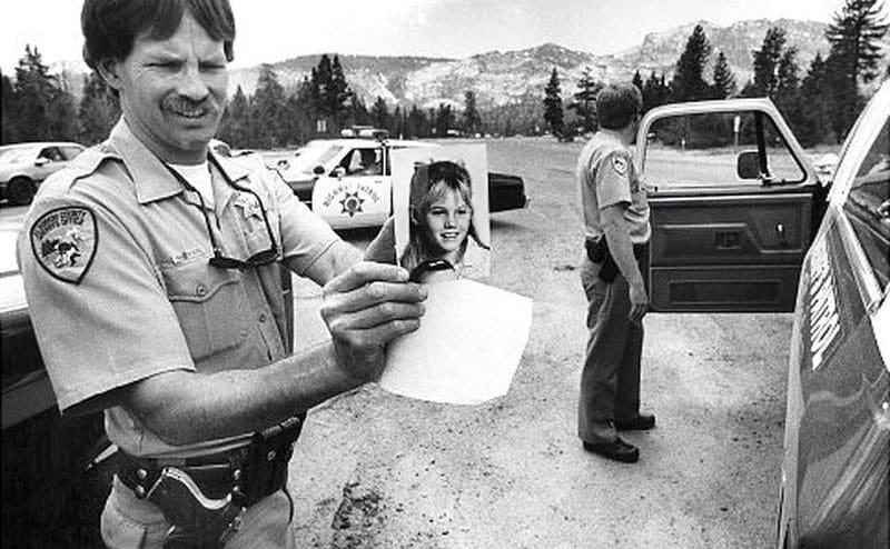 Police officers in patrol showing a photo of the missing kid Jaycee Dugard.