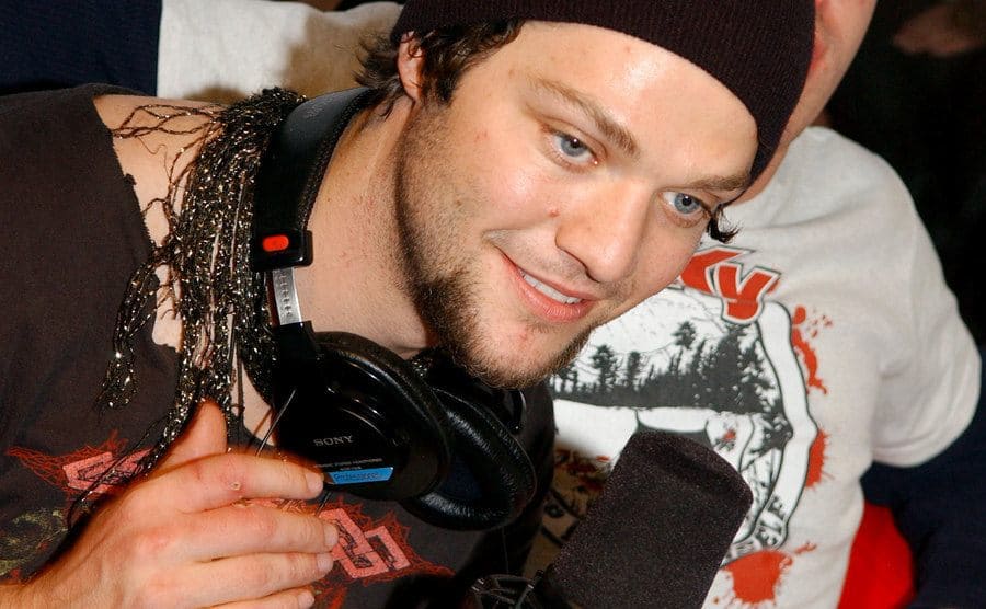 Bam Margera is speaking on the mike in a radio show.