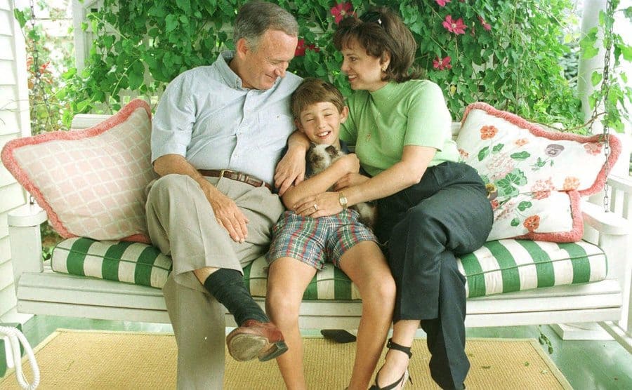 John and Patsy embrace their son Burke as they all sit on the front porch. 