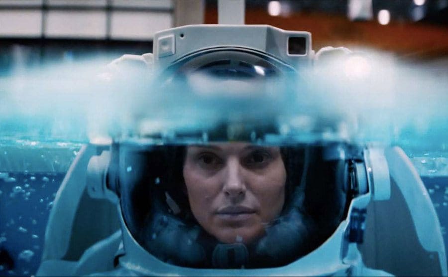 Portman is being submerged underwater in full astronaut gear in a scene from Lucy in the Sky. 