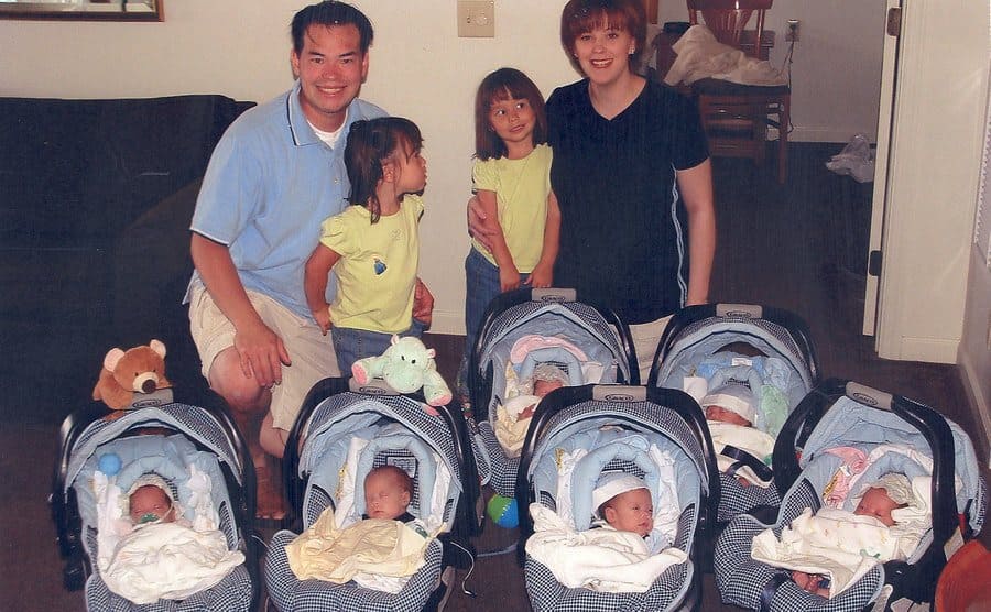 Jon and Kate pose with their twin daughters as all of the sextuplets sleep in baby carriers. 