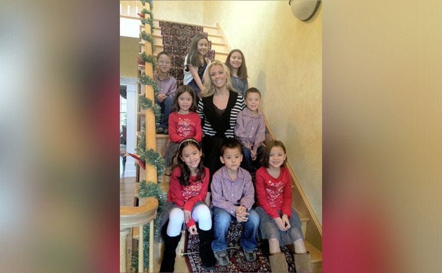 Kate and her kids pose for a photo on the stairs at home.