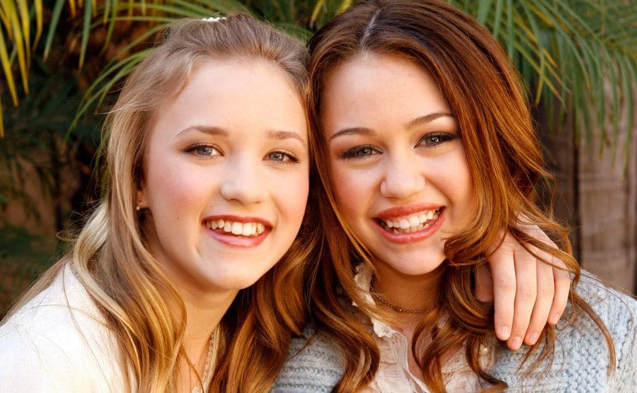 Emily Osment and Miley Cyrus pose together. 