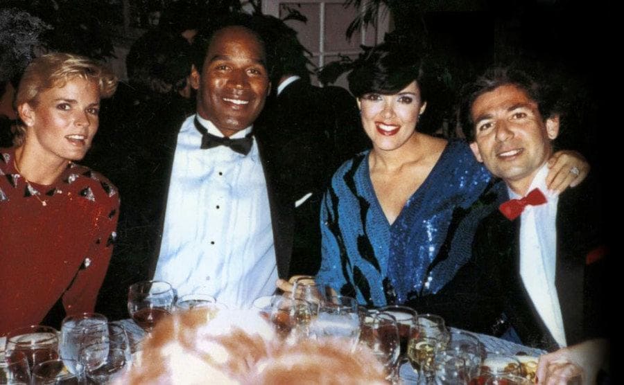 Nicole Brown, O.J. Simpson, Kris Houghton, and Robert Kardashian sit together in a restaurant.