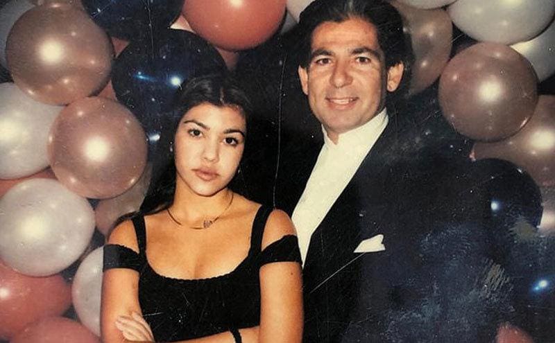 A young Kourtney Kardashian in her teens poses next to her father.