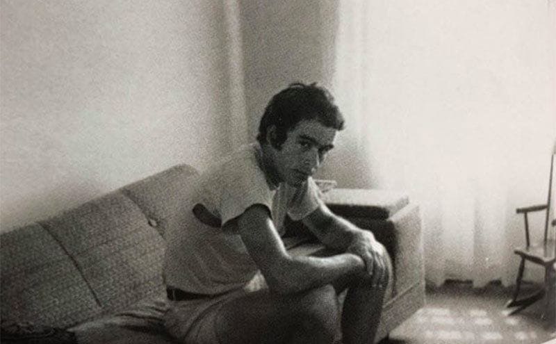 Ted Bundy is sistting on his couch at home. 