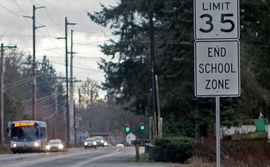 View to the road and the end of school sign. 