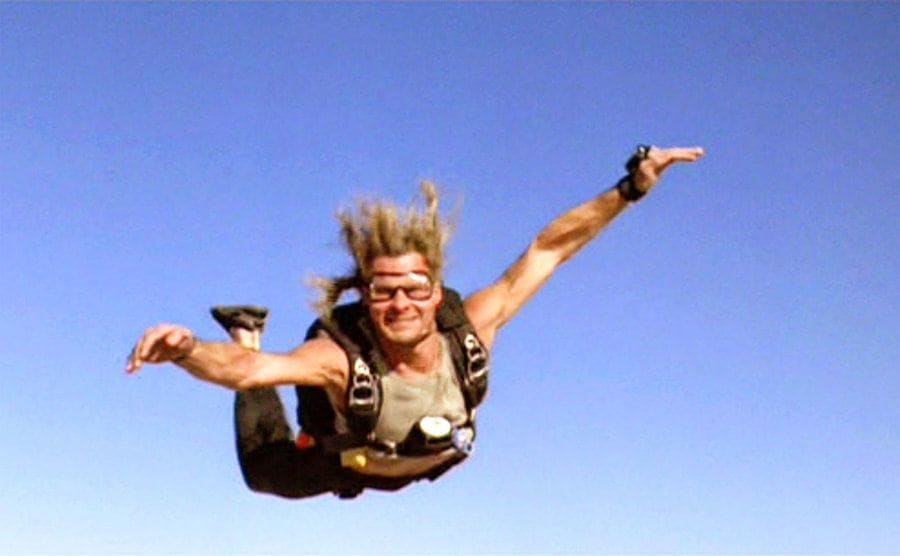 Swayze is skydiving through the air. 