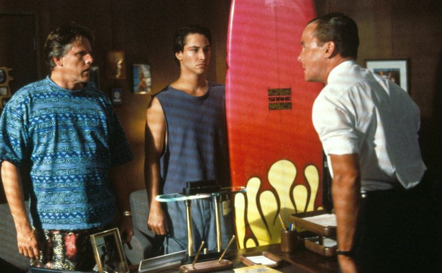 Gary Busey, Keanu Reeves, and John C McGinley in a still from Point Break. 