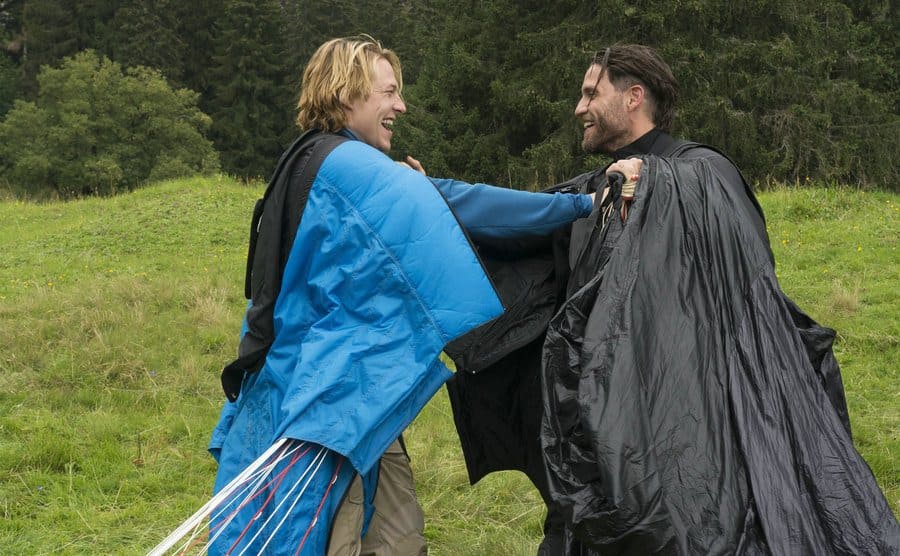 Edgar Ramirez, as Bodhi, and Luke Bracey, as Johnny Utah, embrace after base jumping in a still from the film. 