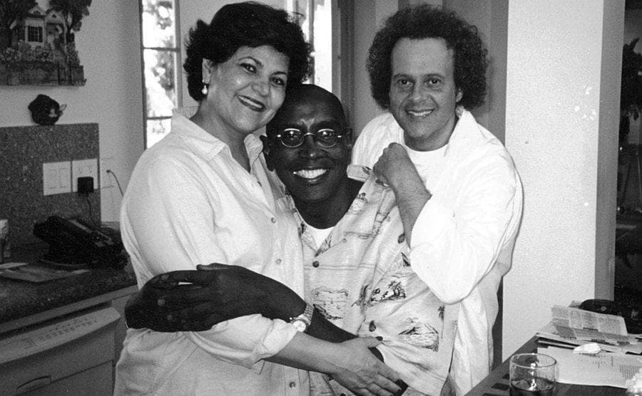 Richard Simmons poses next to a friend and Theresa in the kitchen.