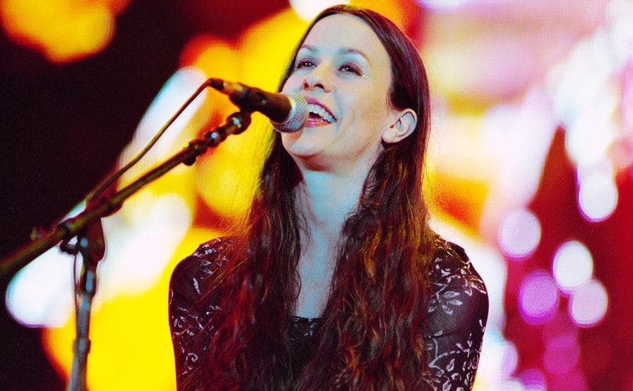 Alanis Morissette is performing onstage.