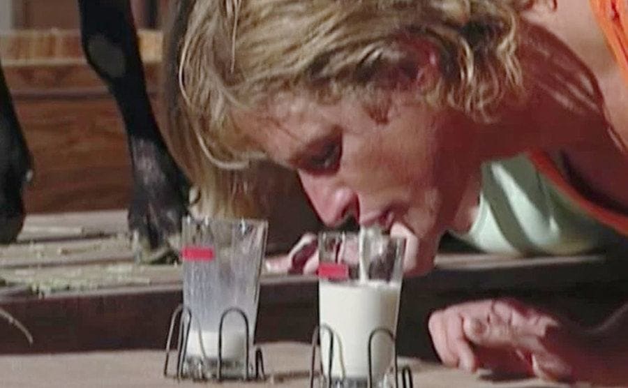 A contestant pours milk in a glass.